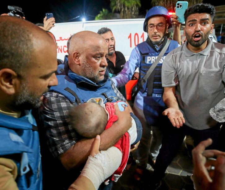 El periodista de Al Jazeera Wael Al-Dahdouh lleva en brazos a uno de sus hijos muertos ayer.