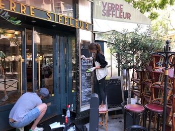 Dos empleados de un restaurante del distrito 14 de París realizan los preparativos para abrir el establecimiento.
