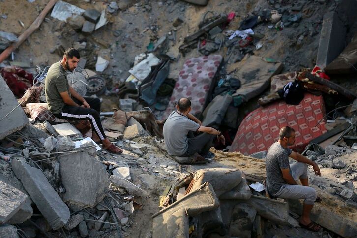  Palestinos sobre los restos de las viviendas destruidas del campo de Yabalia.
