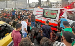 Varias personas se reúnen en torno a una de las ambulancias dañadas en el ataque israelí frente al hospital Al-Shifa.