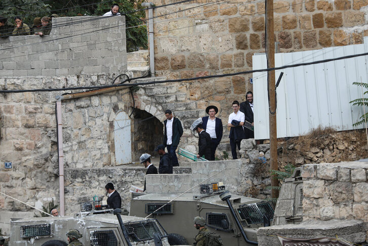 Colonos israelíes esperan entrar a la ciudad vieja de Hebrón protegidos por soldados, el pasado 2 de octubre.