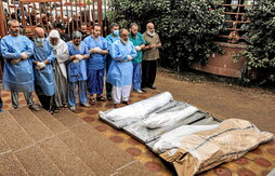 Personal sanitario del hospital Nasser reza ante los cadáveres de varias víctimas del    bombardeo israelí en Jan Yunis antes de su entierro.
