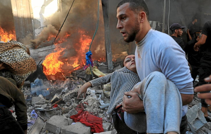 Un hombre lleva a una niña en brazos tras un bombardeo israelí en Rafah, al sur de la Franja.
