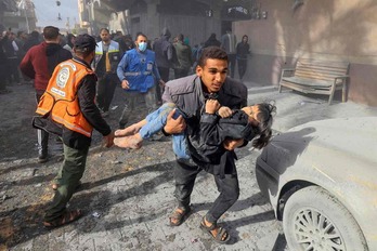   Un hombre lleva a una niña herida tras un ataque en Rafah.