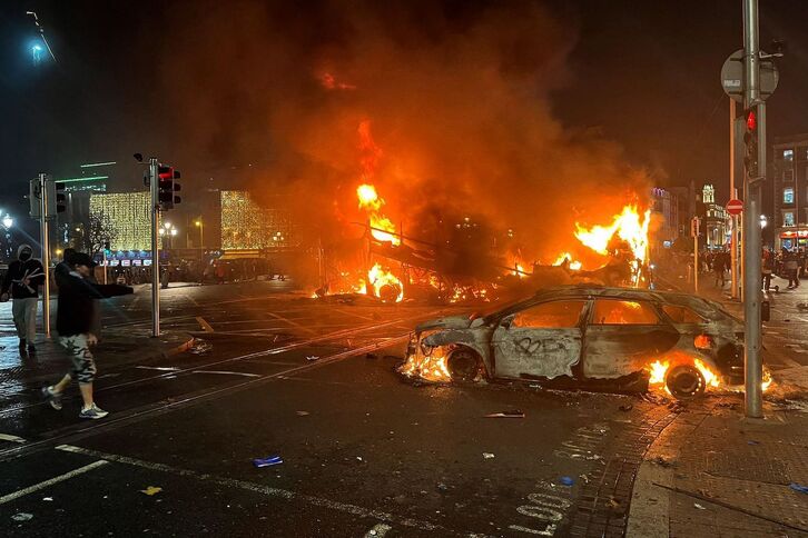 Un coche y un autobus en llamas en Dublín tras los altercados provocados por grupos de extrema derecha. 