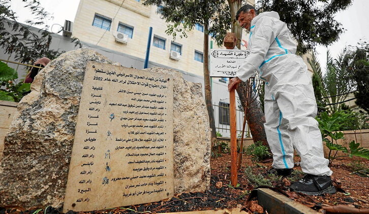 Un trabajador arregla el monumento colocado frente a un hospital de Ramallah en homenaje a los 22 palestinos que mató en 2002 el Ejército israelí al inicio de la Segunda Intifada.