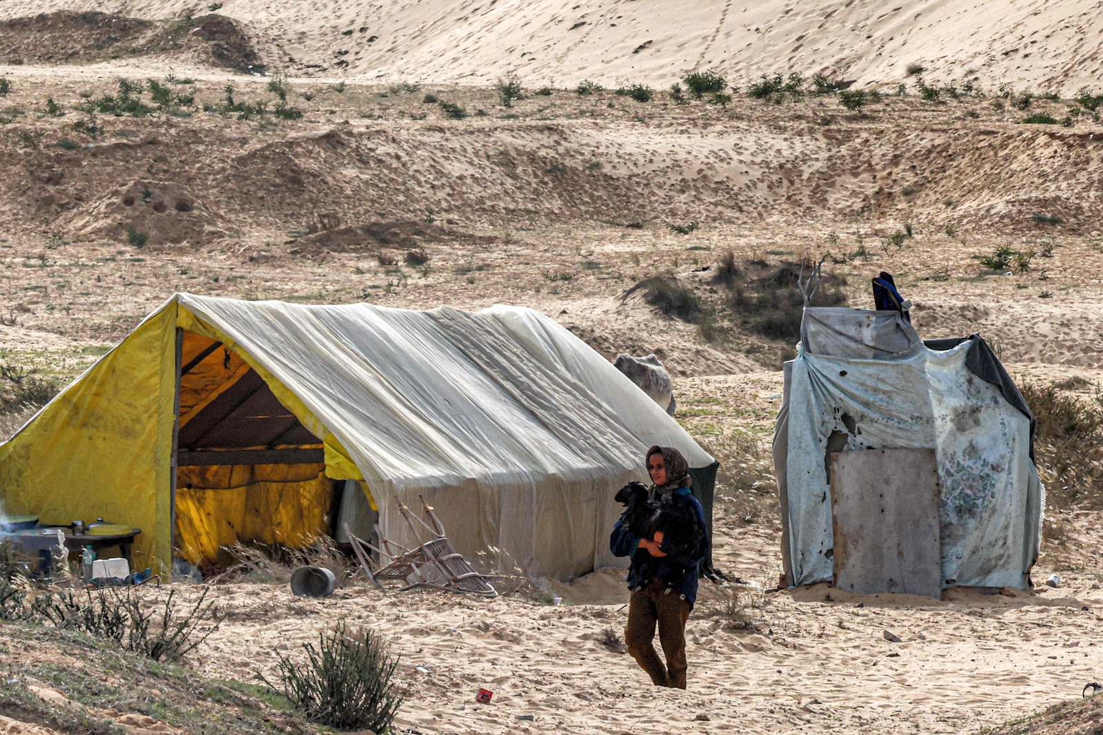 Una ni&ntilde;a camina con una cabra frente a una de las tiendas erigidas por los palestinos desplazados. (Said KHATIB/AFP)