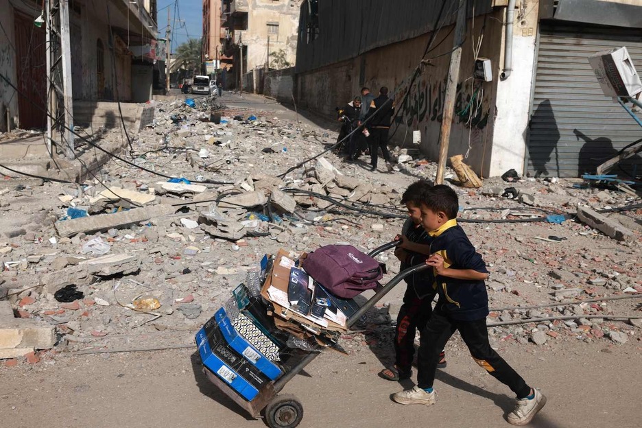 Niños empujan un carro cargado en Rafah.