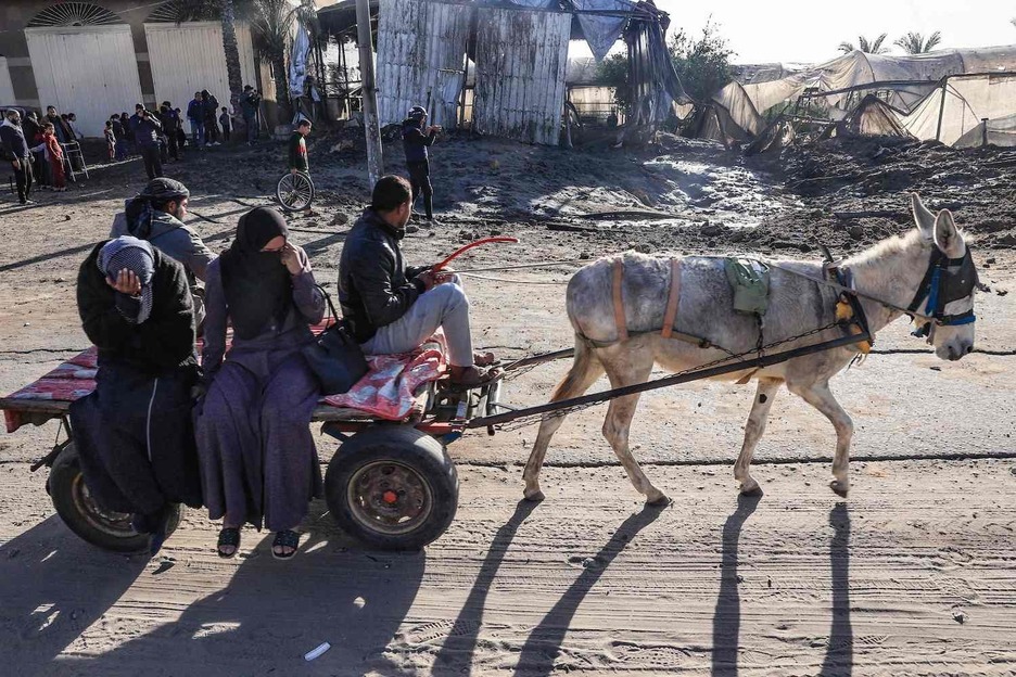 Palestinos utilizan un carro tirado por un burro para huir de Jan Yunis.