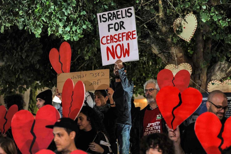Manifestantes a favor de la paz se reúnen con pancartas y carteles en los que piden un alto el fuego en Gaza durante una protesta en la plaza HaBima de Tel Aviv.