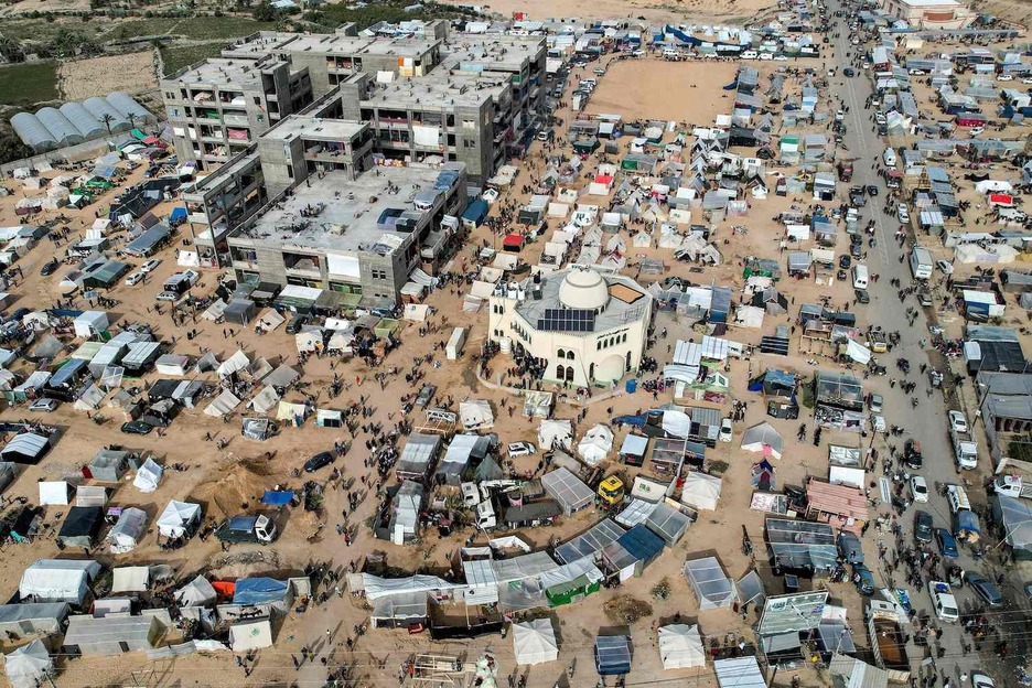 Esta vista aérea muestra los campamentos improvisados de tiendas de campaña que albergan a palestinos desplazados por los intensos bombardeos israelíes que buscan refugio en zonas abiertas alrededor de la mezquita de Raed al-Attar en Rafah.