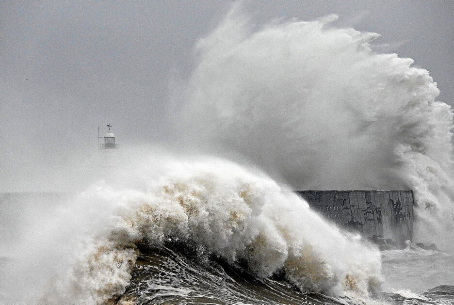 Las olas rompen sobre el faro y el muro del puerto de Newhaven, sur de Inglaterra.