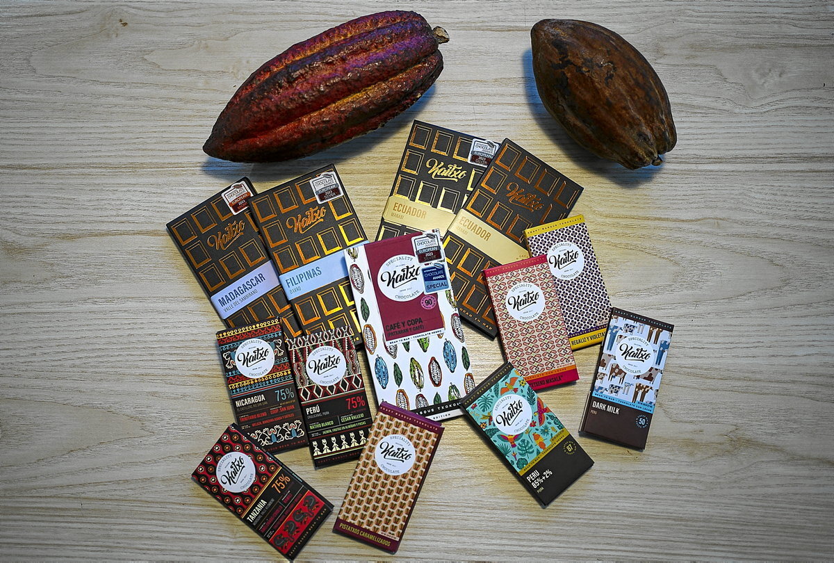 Gama de chocolates de Kaitxo junto a unas habas de cacao.