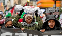 Una mujer levanta la representación de un niño muerto en una manifestación en apoyo a Palestina en Boston, Massachusetts.