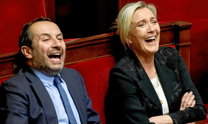 Los ultraderechistas de RN Sebastian Chenu y Marie Le Pen ríen durante la sesión parlamentaria