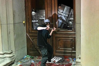 Un manifestante intenta acceder por la fuerza al Ayuntamiento de Belgrado.