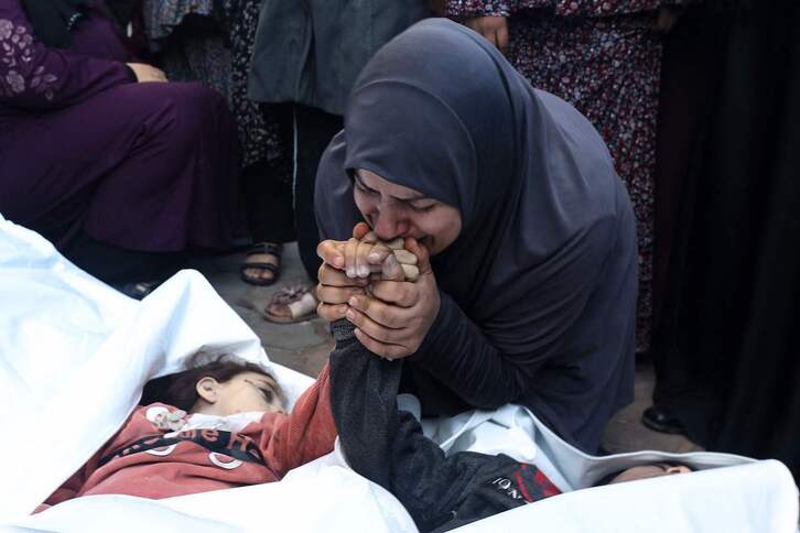La madre de los gemelos de ocho años Ahmed y Jihan Nasser, muertos por las bombas israelíes, besa sus manos.