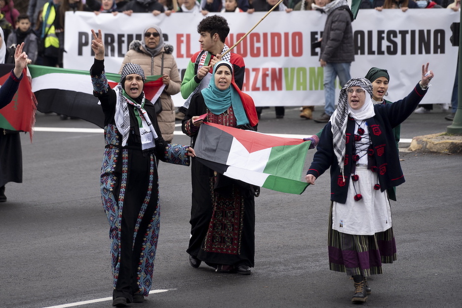 Lau emakume manifestazioan, Palestinako banderarekin.