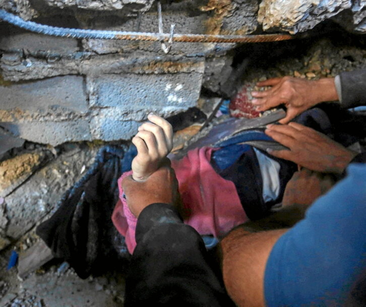 Una niña, atrapada entre los escombros de su casa.