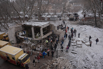 Civiles ayudan a unos trabajadores a reparar los daños causados por las tuberías de un edificio residencial tras el ataque masivo con misiles que sacudió Kiev el pasado 2 de enero.