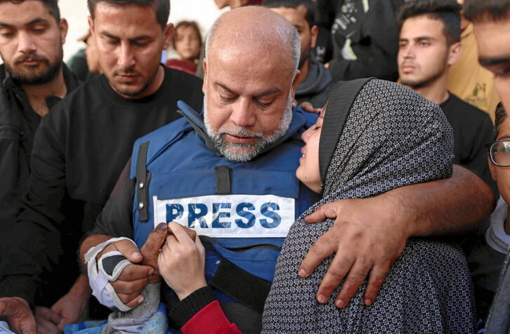 Wael al-Dahdouh y su hija, abrazados, sostienen la mano de Hamza.