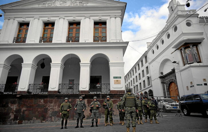 Fuerzas de seguridad hacen guardia mientras miembros del cuerpo diplomático llegan al Palacio de Carondelet, en Quito.