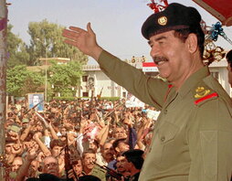 Saddam Hussein saluda a sus seguidores.