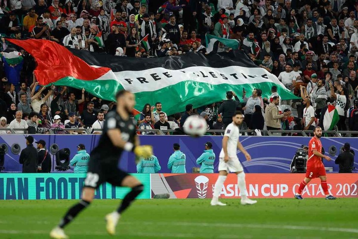 Los aficionados ondean una bandera con el lema "Free Palestine" en el partido ante Irán.
