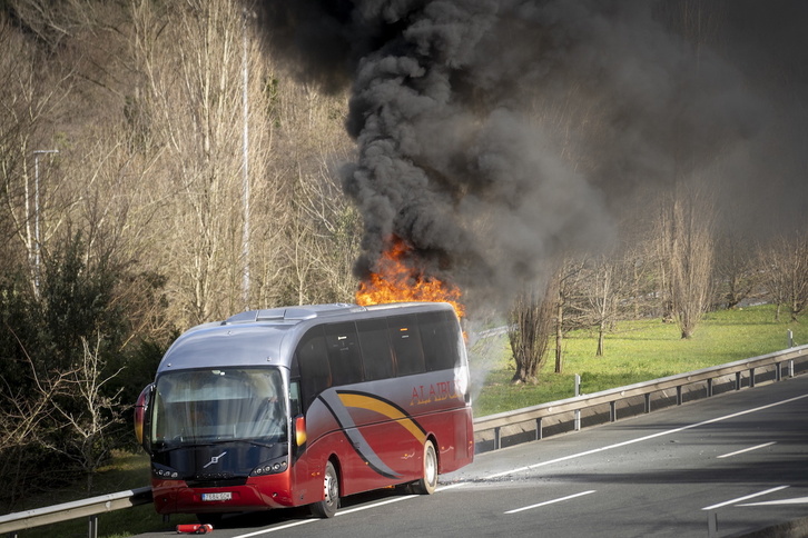 El autobús incendiado en la AP-8, en el arcén.