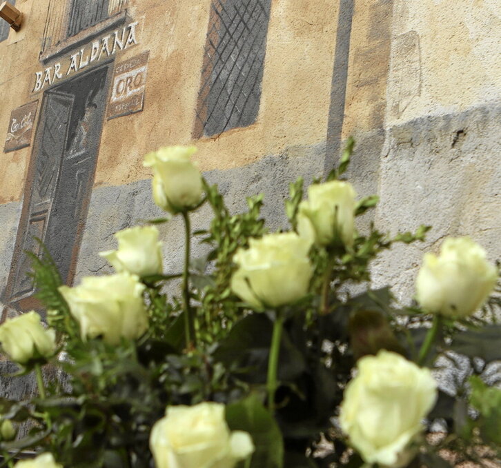 Ramo de flores junto al mural que recuerda el bar Aldana, en Alonsotegi.