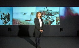 La videocreadora Beatriz Caravaggio, ante la cuádruple pantalla donde se exhibe su película.