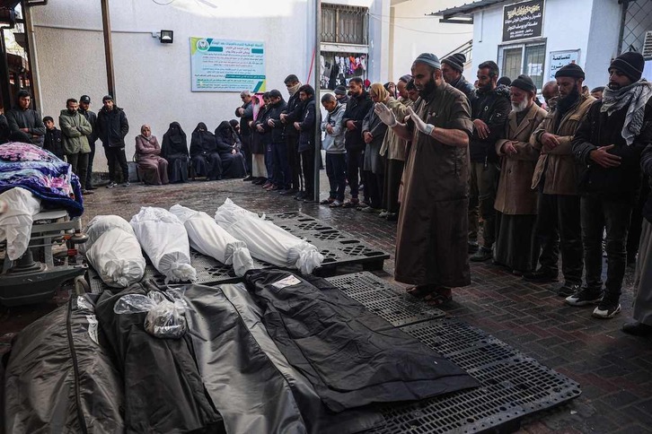 Palestinos rezan junto a los cadáveres de familiares muertos en un bombardeo israelí sobre Rafah.