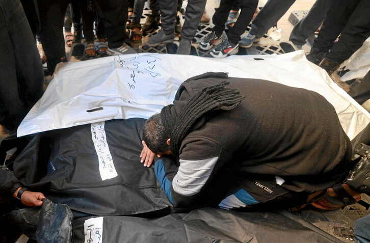 Un palestino llora sobre el cuerpo amortajado de un familiar en un hospital de Rafah.