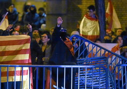 A la izquierda, un joven embozado hace el saludo fascista durante una manifestación contra la amnistía frente a la sede del PSOE en Ferraz. Arriba, un joven seguidor de Donald Trump anima al expresidente durante un mitin de campaña New Hampshire.