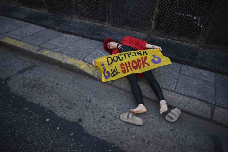 Un manifestante con una nariz de payaso sostiene una pancarta en la que se lee ‘Doctrina del Shock’ durante una protesta frente al Congreso mientras los legisladores debaten el proyecto de ley.