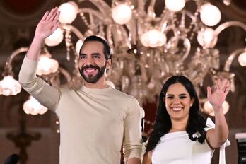 El presidente de El Salvador, Nayib Bukele, y su esposa, Gabriela Rodriguez, saludan a sus seguidores en la noche electoral..