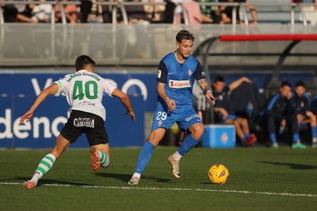 Troncho conduce el balón en Lezama frente a un jugador del Racing.