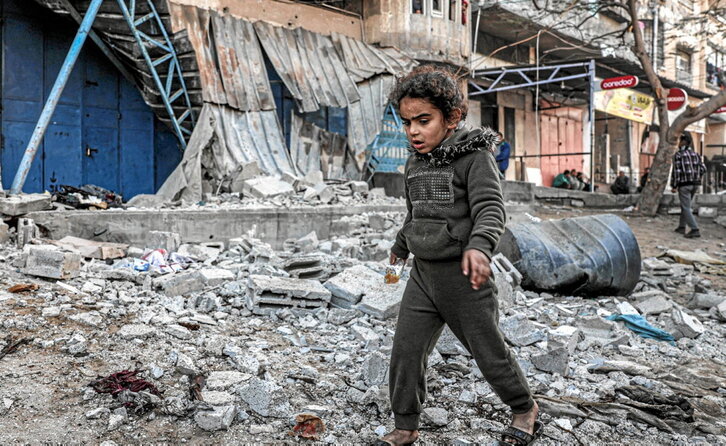 Una niña camina entre los restos de edificios tras un bombardeo israelí en Rafah.