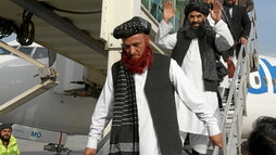 Abdul Karim, con barba roja, y Abdul Zahir, con los brazos en alto, descienden del avión en Kabul.