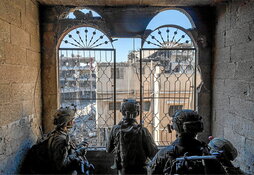 Soldados israelíes contemplan varios edificios destruidos en Gaza.