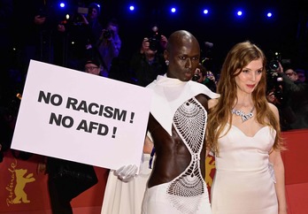 La actriz alemana Pheline Roggan, en la gala inaugural con un cartel contra la presencia del partido ultraderechista AFD.