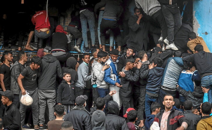 Palestinos se agolpan en el exterior de una panadería para conseguir algo de pan en Rafah.