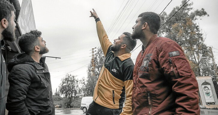Jóvenes libaneses señalan al cielo donde se avistan cada vez más drones israelíes.