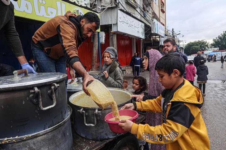 Menores palestinos reciben comida en Rafah.