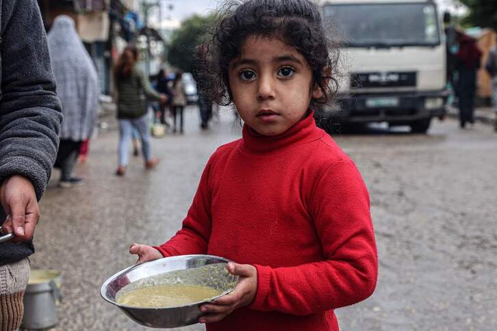 Una niña palestina, con un plato de sopa en Rafah.
