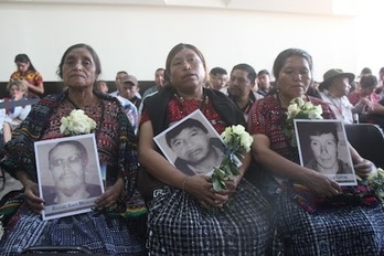 Mujeres indígenas muestran los retratos de sus familiares a los que el Ejército mató.