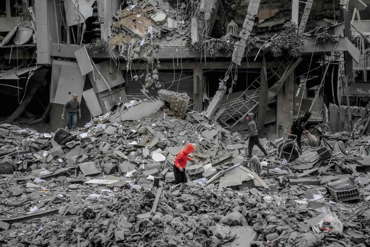 Palestinos buscan algo que recuperar entre las ruinas dejadas por las bombas israelíes en la ciudad de Gaza.