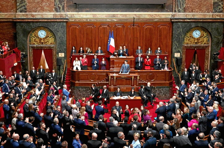 Diputados y senadores franceses aplauden tras la aprobación de la reforma.