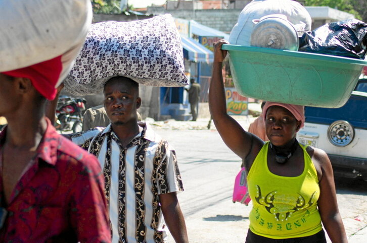 Port-au-Prince hiriburuko bizilagunak ihesean, beren ondasun urriak hartuta.