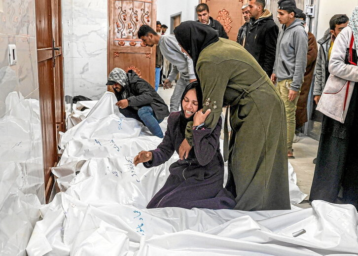 Miembros de la familia Al-Faqawi lloran a los 17 familiares muertos en Jan Yunis.